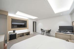 a bedroom with a large bed with a flat screen tv at 드므호텔 in Changwon