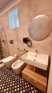 a bathroom with a sink and a toilet and a mirror at Eureka Apartment in Noto +37 photos