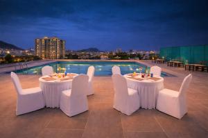 a patio with two tables and chairs and a pool at Hotel Royal Aravali in Udaipur