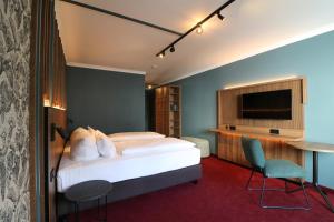 a hotel room with a bed and a tv at Hotel Haverkamp in Bremerhaven