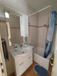 a bathroom with a sink and a toilet and a tub at Apartments Milevčić in Jelsa +25 photos
