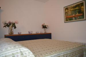 a bedroom with a bed and two vases with flowers at Borgo nel Centro in Ronciglione
