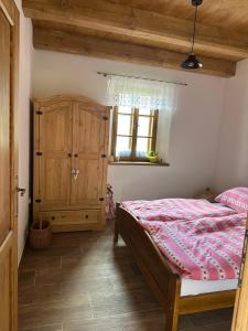 a bedroom with a bed and a wooden cabinet at Chalupa Vlachovice in Vlachovice