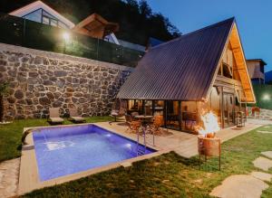 a house with a swimming pool next to a stone building at Tina Bungalov in Sapanca