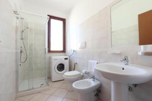 a bathroom with a sink toilet and a washing machine at ModernShore - Oltremare in Tortoreto Lido +49 photos