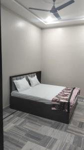 a bedroom with a bed with white walls and a ceiling at Nikunj dham in Vrindāvan