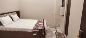 a bedroom with a bed and a tv on the wall at Nikunj dham in Vrindāvan