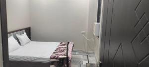 a small bedroom with a bed and a phone at Nikunj dham in Vrindāvan