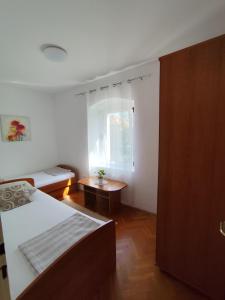 a small room with a bed and a window at Apartments Milevčić in Jelsa