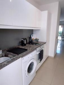 a kitchen with a washing machine and a sink at Modern Studio apartment Armonia Court in Paralimni