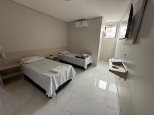 a hospital room with two beds and a window at Hotel Impactus Santo Amaro in São Paulo