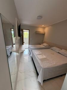a room with three beds and a mirror at Hotel Impactus Santo Amaro in São Paulo +13 photos