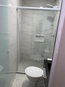 a bathroom with a toilet and a glass shower at Hotel Impactus Santo Amaro in São Paulo