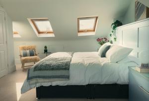 a bedroom with a bed with white sheets and a chair at The Nest in Bristol