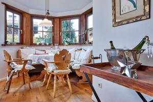 a dining room with a table and chairs and windows at Minerva in Farchant +20 photos