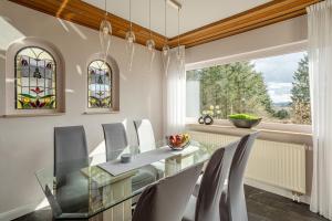 a dining room with a glass table and chairs at Green Eifel Casa in Feusdorf