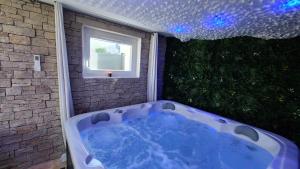 a bath tub in a bathroom with a window at Love room le bain in Le Val