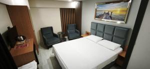 a small room with a bed and two chairs at Lantis Otel in Avcılar