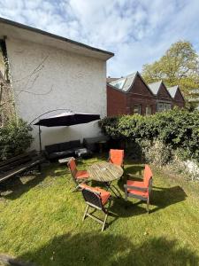Eine Gruppe von Stühlen und ein Sonnenschirm in einem Garten in der Unterkunft Moderne Wohnung mit Garten - Top Lage im schönen Mauritzviertel in Münster