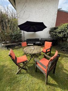 eine Terrasse mit Tisch, Stühlen und Sonnenschirm in der Unterkunft Moderne Wohnung mit Garten - Top Lage im schönen Mauritzviertel in Münster + 5 Fotos