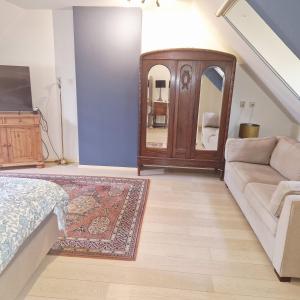 a living room with a couch and a mirror at B&B Chez Paz in Neer