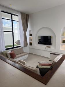 a living room with a couch and a tv at Nook Villas in Bagamoyo