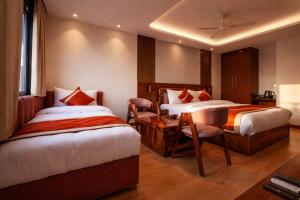 a hotel room with two beds and a table and chairs at RLS Hotels, Greater Noida Near Expo Centre & Mart in Greater Noida