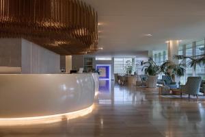 a lobby with chairs and a reception desk in a building at Amadria Park Beach Hotel Jure in Šibenik