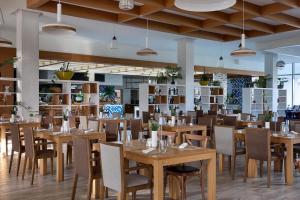 a dining room with wooden tables and chairs at Amadria Park Beach Hotel Jure in Šibenik