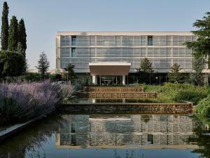a building with a pond in front of a building at Amadria Park Beach Hotel Jure in Šibenik