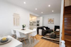a kitchen and living room with a white table and chairs at Faial Inn in Horta
