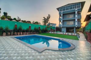 a swimming pool in front of a building at Harmony Palace in Mahabaleshwar