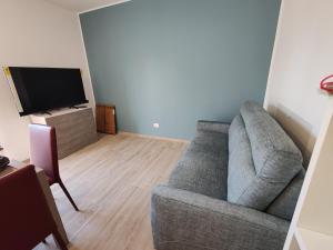 a living room with a couch and a flat screen tv at SunshineSuite in Alassio