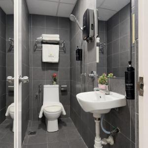 a bathroom with a toilet and a sink at Swiss Hotel Kuala Lumpur in Kuala Lumpur +29 photos