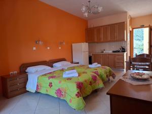 a bedroom with a large bed with a green blanket at Avra Apartments in Leonidio