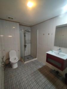 a bathroom with a toilet and a shower and a sink at RedHouse Boutique in Sihanoukville