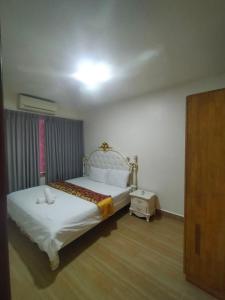 a bedroom with a bed with a white bedspread at RedHouse Boutique in Sihanoukville