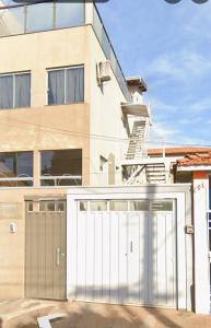 a white garage door in front of a house at Lindo Loft no centro de Assis in Assis