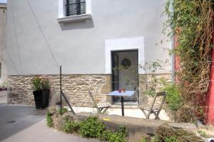 une table et des chaises devant un bâtiment dans l'établissement Le 22 grand rue, à Rezé