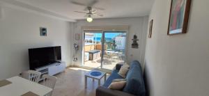 a living room with a blue couch and a television at A & G Casares Costa in San Luis de Sabinillas