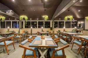a restaurant with wooden tables and chairs and windows at Harmony Palace in Mahabaleshwar
