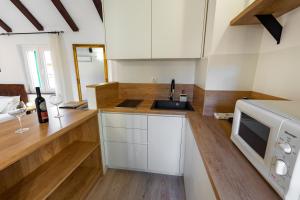 a kitchen with white cabinets and a sink and a microwave at Guesthouse Imperator in Split