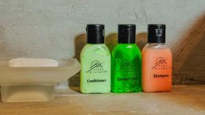 three bottles of shampoo and soap sitting on a counter at Villa Evermist in Nuwara Eliya