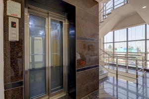 a glass elevator in a building with a balcony at FabHotel NA Grand in Chennai
