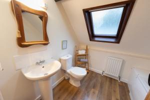 a bathroom with a toilet and a sink and a mirror at Stable Cottage Wheddon Cross in Wheddon Cross +85 photos