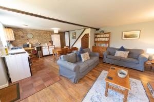 a living room with two couches and a table at Rose Cottage Wheddon Cross in Wheddon Cross