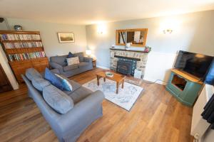 a living room with a couch and a fireplace at Rose Cottage Wheddon Cross in Wheddon Cross