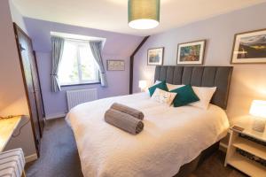 a bedroom with a large bed with purple walls at Rose Cottage Wheddon Cross in Wheddon Cross