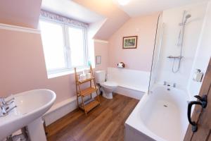 a bathroom with a sink and a tub and a toilet at Rose Cottage Wheddon Cross in Wheddon Cross +92 photos