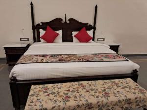 a bedroom with a large bed with red pillows at Tej Gadh Jambuda in Sālūmbar